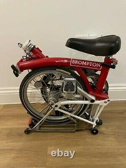 M3R folding Brompton in red and white. Front/rear dyno light, mudguard and rack